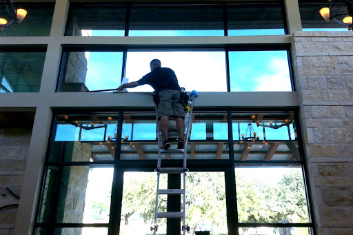 commercial window tint montreal technician climbing on ladder to apply tint